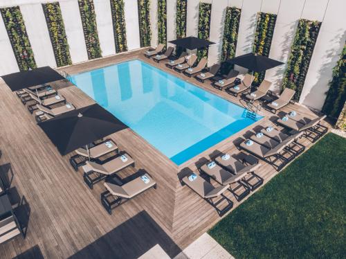 an overhead view of a swimming pool with chairs and umbrellas at Iberostar Selection Lisboa in Lisbon