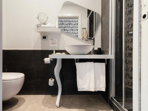 a bathroom with a sink and a toilet at Montenapoleone Suites in Milan