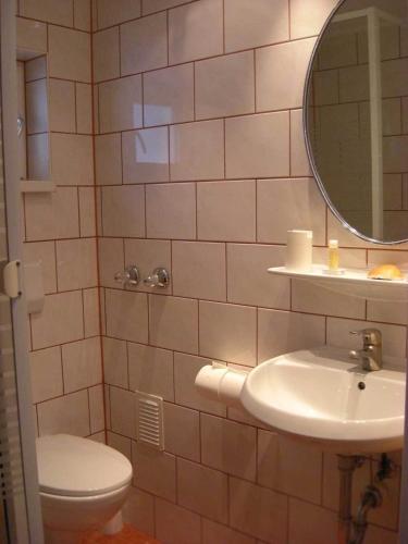 a bathroom with a toilet and a sink and a mirror at Hotel Mariahilf München in Munich