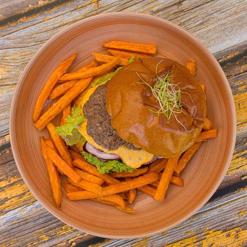 a plate of food with a hamburger and french fries at Jam Panzió in Kapuvár