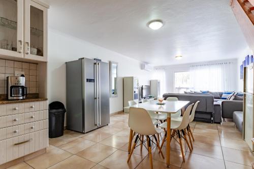 a kitchen and living room with a table and a refrigerator at Mzingazi Waterfront Accommodation, On The Bay Waterfront Villa's in Richards Bay