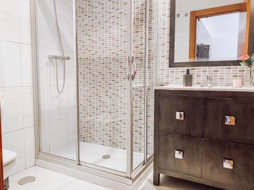 La salle de bains est pourvue d'une douche avec une porte en verre. dans l'établissement Monte Cerrau, apartamento con plaza de garaje y WIFI, à Oviedo