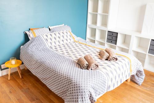 une chambre avec un lit avec deux pantoufles dessus dans l'établissement Elegant T3 entre Gare et Coeur de ville par Groom*, à Lorient