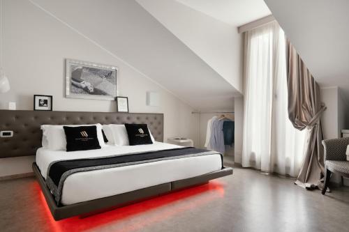 a bedroom with a large bed with a red light on it at Montenapoleone Suites in Milan