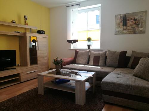 ein Wohnzimmer mit einem Sofa und einem Couchtisch in der Unterkunft Ferienwohnung - August-Bebel-Str. 19 in Oelsnitz