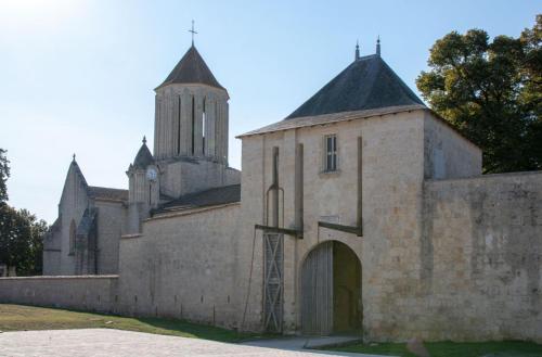 an old stone church with a tower and a door at H de Surgères in Surgères