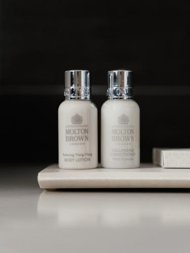 two bottles ofodorizers are sitting on a shelf at Montenapoleone Suites in Milan