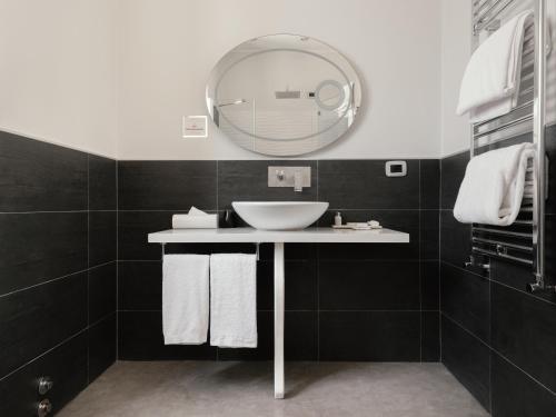 a bathroom with a sink and a mirror at Montenapoleone Suites in Milan