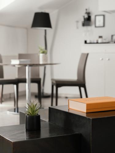 a table with a book and a table with a chair at Montenapoleone Suites in Milan