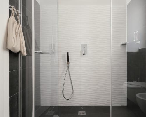 a bathroom with a shower with a glass door at Montenapoleone Suites in Milan