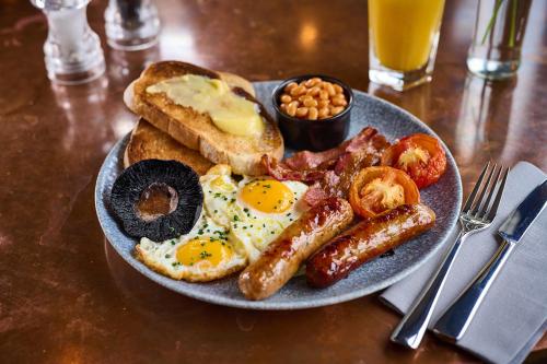 a plate of breakfast food with eggs bacon and toast at The Curious Pig in the Parlour in Burstow