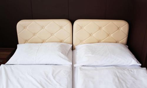 a bed with white sheets and pillows at Hotel Ďumbier in Brezno