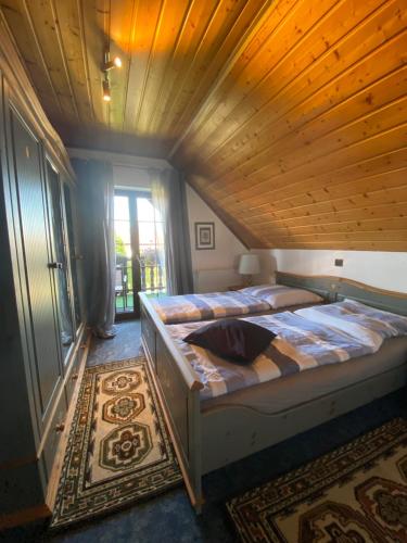 - une chambre avec un grand lit et un plafond en bois dans l'établissement Appartement am Stadtpark, à Ochtrup