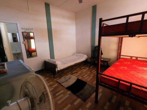 a bedroom with two bunk beds and a fan at Stargaze Backpackers Hostel in Guwahati