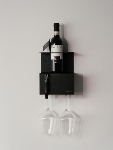 a wine bottle and two glasses hanging from a wall at Montenapoleone Suites in Milan