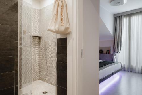 a bathroom with a shower and a walk in shower at Montenapoleone Suites in Milan