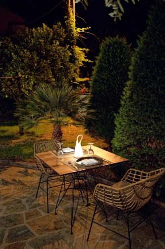 a wooden table with two chairs and a swan on it at Alfa Hotel in Parga