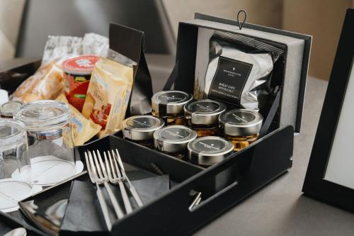 a black box with food and utensils on a table at Montenapoleone Suites in Milan