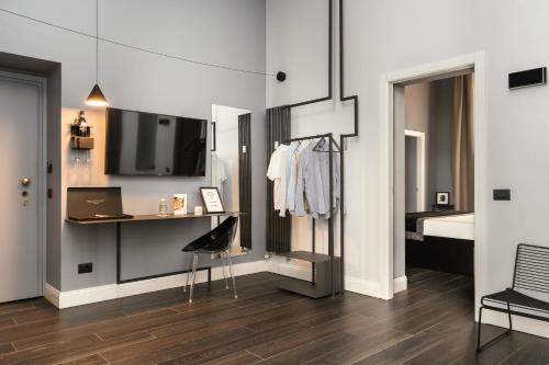 a bedroom with a desk and a bed with a tv at Montenapoleone Suites in Milan