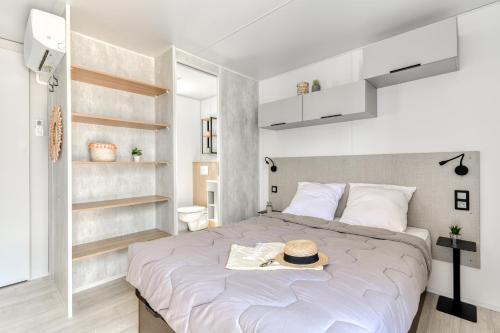 una camera da letto con un letto con un cappello sopra di Camping maeva Escapades Les Cottages de Perpignan a Perpignano
