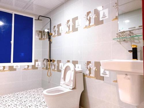OYO 1170 Nhan Duc Hotel في مدينة هوشي منه: حمام مع مرحاض ومغسلة