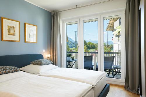 sypialnia z łóżkiem i widokiem na balkon w obiekcie Redlok w Garmisch Partenkirchen