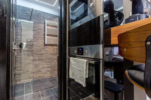 Il comprend une cuisine équipée d'un four micro-ondes et d'une porte en verre. dans l'établissement Goldcentral Apartments Akacfa Studios, à Budapest