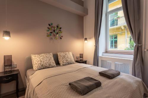 - une chambre avec un lit avec deux oreillers et une fenêtre dans l'établissement Goldcentral Apartments Akacfa Studios, à Budapest
