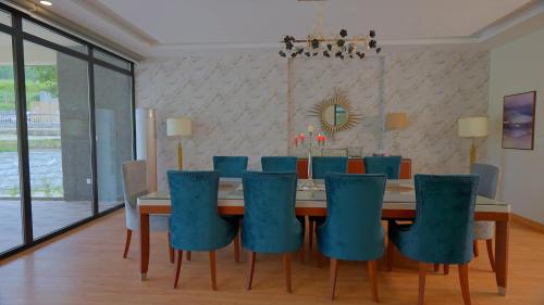 a dining room with a table and blue chairs at Marco Polo Resort Kaghan in Kāgān