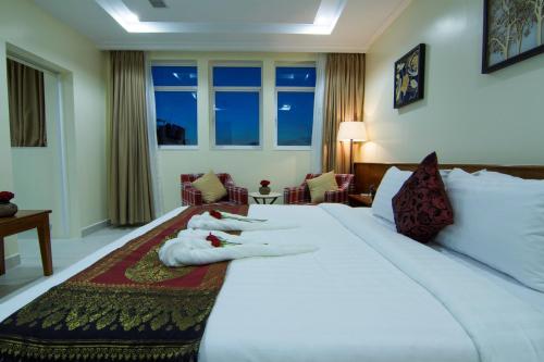 a person laying on a bed in a hotel room at Rose Emerald Hotel in Phnom Penh