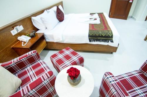 a hotel room with a bed and a table and chairs at Rose Emerald Hotel in Phnom Penh