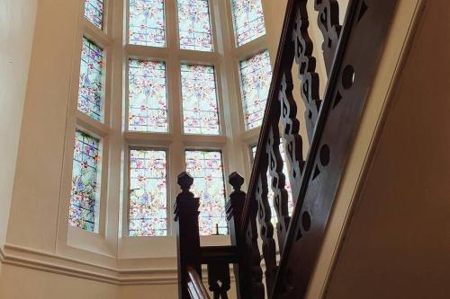 a staircase with a stained glass window at Country Manor House with indoor Pool and Hot Tub in Rochester