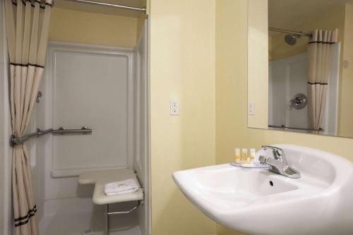 a bathroom with a sink, toilet and shower at Days Inn by Wyndham Denver Downtown in Denver