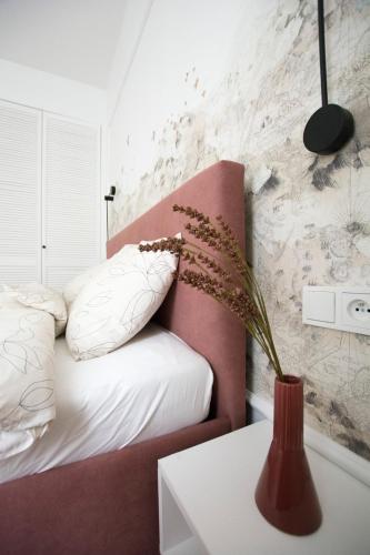 a bedroom with a bed and a vase on a table at Apartament Grzaniec in Szklarska Poręba