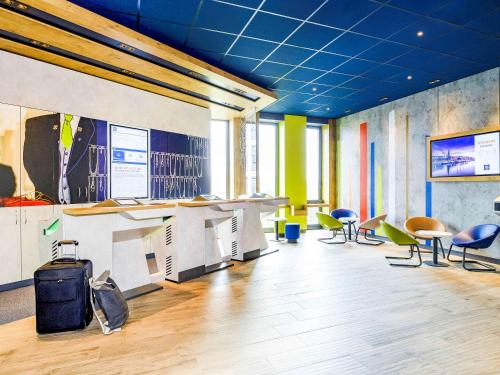 an office with chairs and tables and a blue ceiling at ibis budget Bremen City Center in Bremen