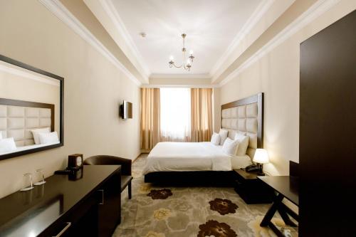 エレバンにある14 Floor Hotelのベッドとデスクが備わるホテルルームです。