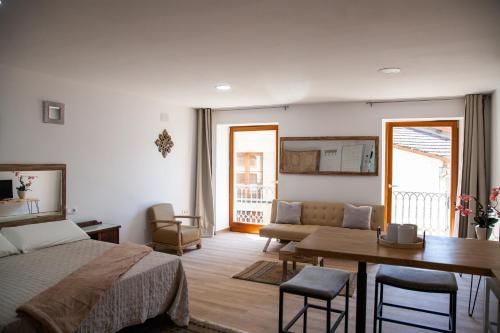 a bedroom with a bed and a table and a dining room at A casa do Xastre in Allariz