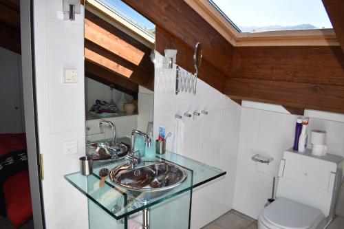 La salle de bains est pourvue d'un lavabo en verre et de toilettes. dans l'établissement Beal Lia Haus C 474 Bh Whg 8, à Lenz