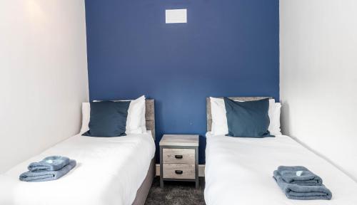 twee bedden naast elkaar in een kamer bij Comfortable 3 Bed House with Parking, WiFi & Patio by Ark SA in Handsworth