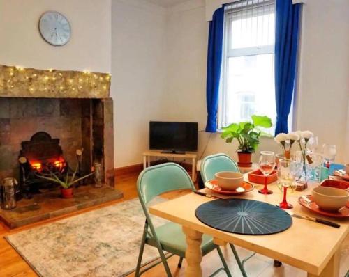 a dining room with a table and a fireplace at 2 bedroom Victorian canal side terrace house. in Hebden Bridge