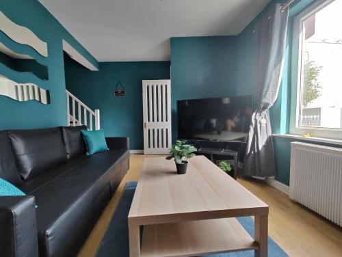 a living room with a black couch and a table at Recently Renovated Dublin City House in Dublin