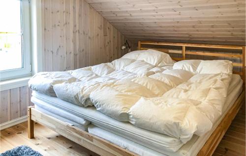 a large bed with white sheets on it in a room at Cozy Home In Brttum With Kitchen in Skrukkerud