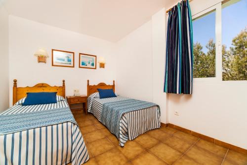 Un pat sau paturi într-o cameră la Globales Apartamentos Cala Viñas ONLY ADULTS 16