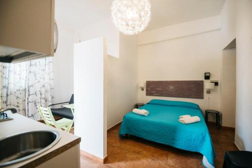 メッシーナにあるVilla Scilla e Cariddiの青いベッドとシンクが備わる小さな客室です。