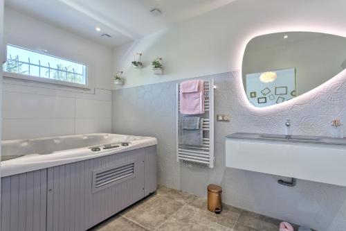 W łazience znajduje się wanna, umywalka i lustro. w obiekcie L'AppartHé w Aix-les-Bains
