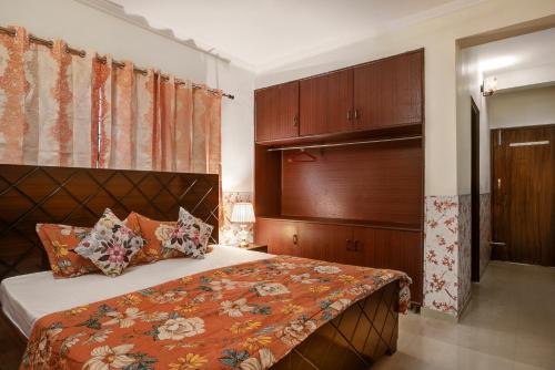 a bedroom with a bed with a wooden headboard at Meera Homes in Dehradun
