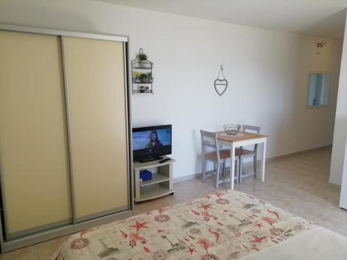 a living room with a television and a dining room table at Apartmani ROKO, Sevid in Marina