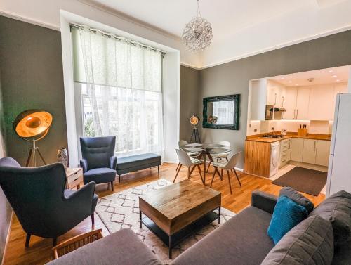 een woonkamer met een bank en een tafel bij Modern 3 Bedroom Apartment in Kensington in Londen