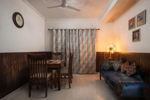 a living room with a table and a couch at Meera Homes in Dehradun