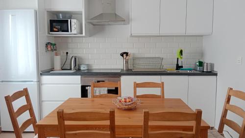 una cocina con una mesa con un bol de fruta. en Apartamento nuevo cerca de la costa y a 15 min de Bilbao!, en Urduliz
